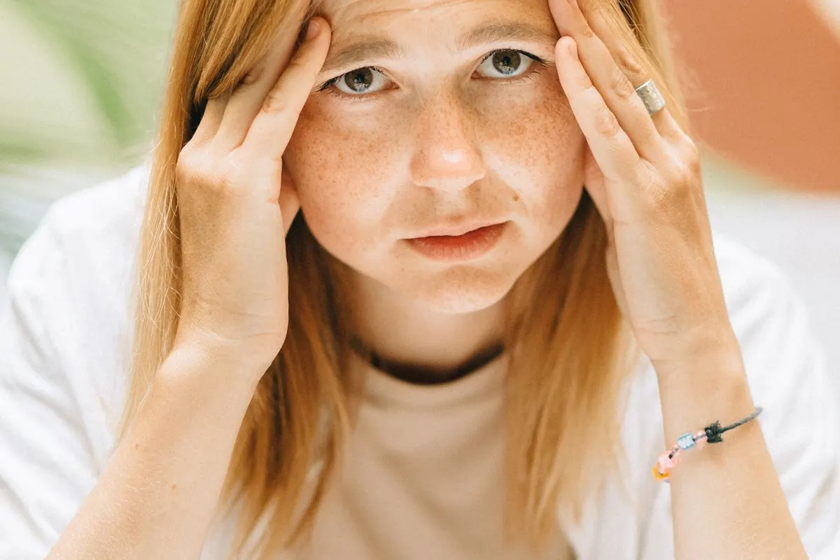 Femme stressée, les mains sur les tempes